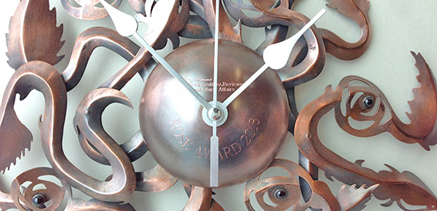Detail: Climbing Roses Clock | Copper, clock mechanism and Garnets | Diameter 27 cm x Height 5 cm | Copper was scored by etching and oxidised. The garnets were bezel set in Sterling silver. Close-up image of Climbing Roses Clock